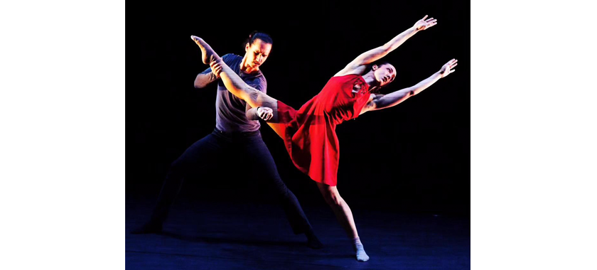 Two dancers photographed against a dramatic black background